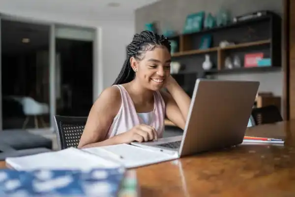 A high school learner studying on her laptop at home